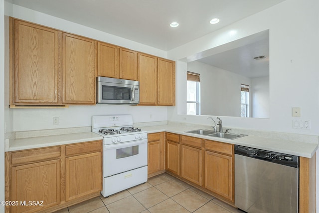 kitchen featuring light tile patterned floors, visible vents, stainless steel appliances, light countertops, and a sink