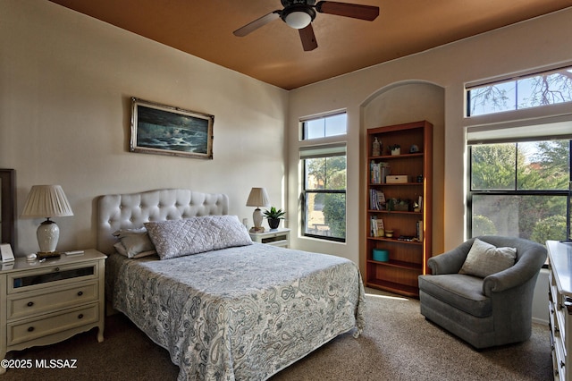 bedroom with ceiling fan and dark colored carpet