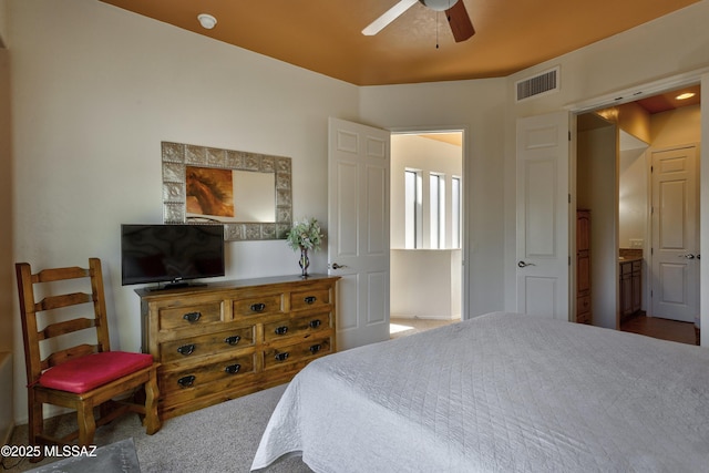 bedroom with ceiling fan, carpet flooring, and ensuite bath