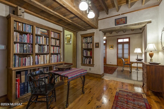 living area featuring beamed ceiling, wood ceiling, and hardwood / wood-style floors