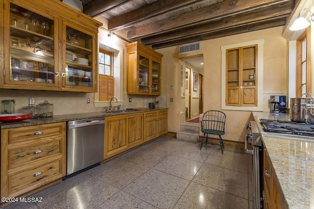 kitchen with light stone countertops, appliances with stainless steel finishes, sink, and beam ceiling