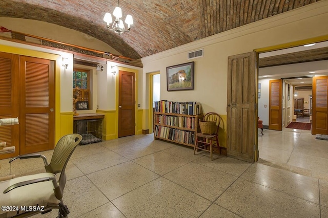 office with a chandelier, lofted ceiling, and brick ceiling