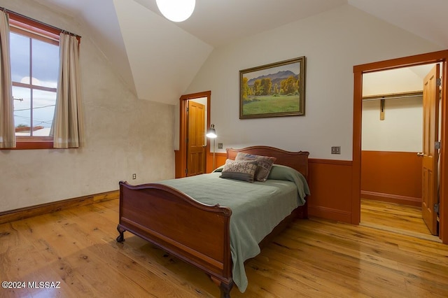 bedroom featuring light hardwood / wood-style floors, a closet, and vaulted ceiling