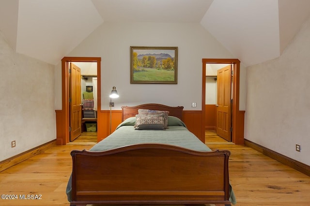 bedroom featuring light hardwood / wood-style floors and vaulted ceiling