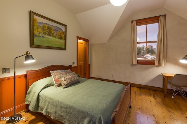 bedroom with light hardwood / wood-style floors and lofted ceiling