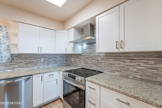 kitchen featuring white cabinetry, wall chimney range hood, appliances with stainless steel finishes, and tasteful backsplash