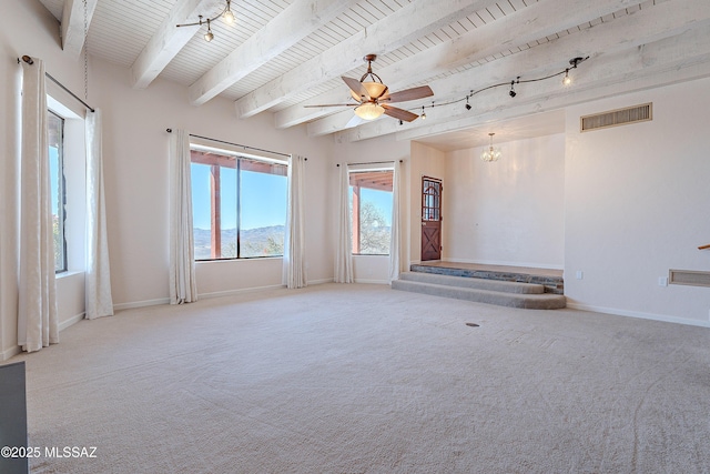 carpeted spare room with a mountain view, ceiling fan with notable chandelier, plenty of natural light, and beamed ceiling