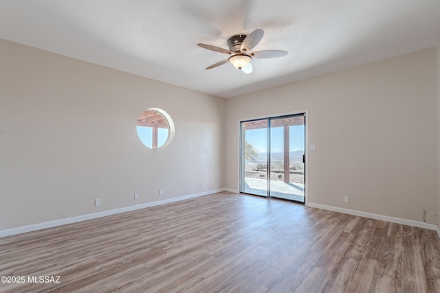 empty room with ceiling fan, a textured ceiling, and light hardwood / wood-style flooring