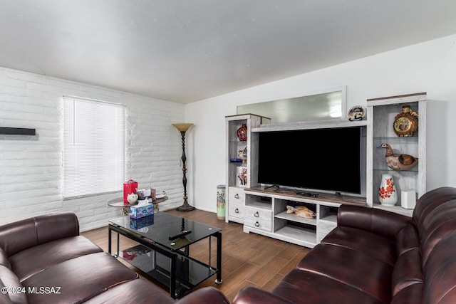 living room with brick wall and dark hardwood / wood-style floors