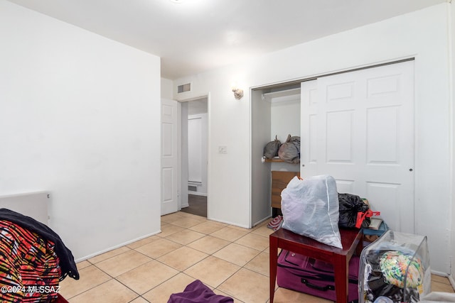 bedroom with light tile patterned floors and a closet