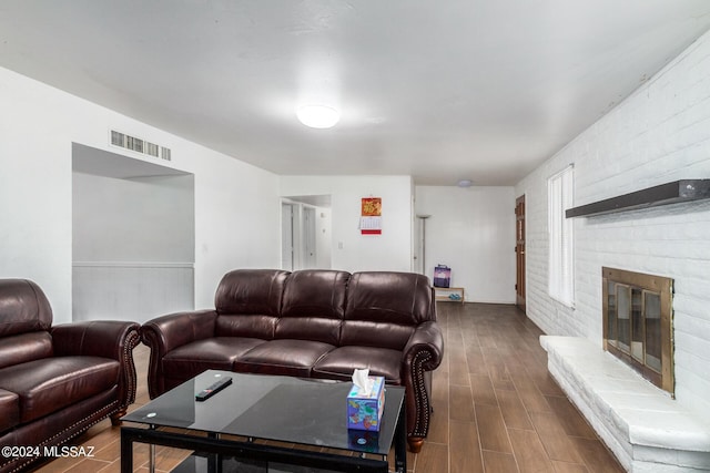 living room featuring hardwood / wood-style floors and a brick fireplace