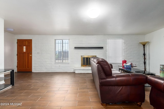 living room featuring brick wall and a fireplace