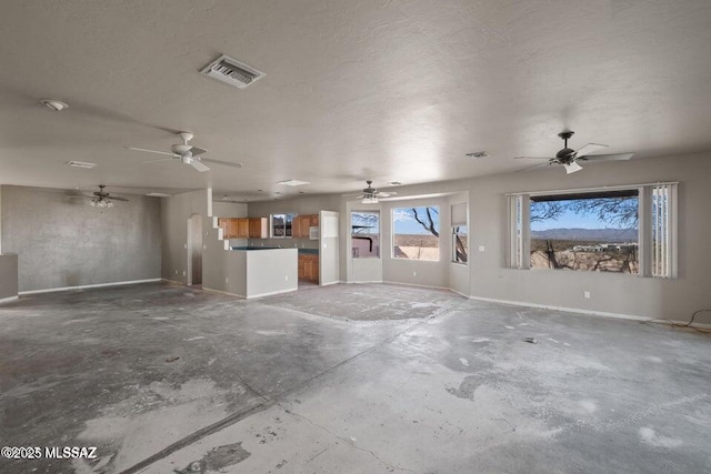 unfurnished living room featuring concrete flooring and a textured ceiling