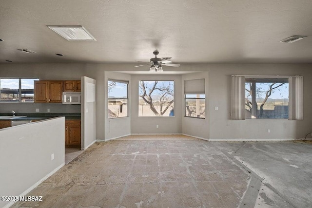 unfurnished living room with ceiling fan and sink