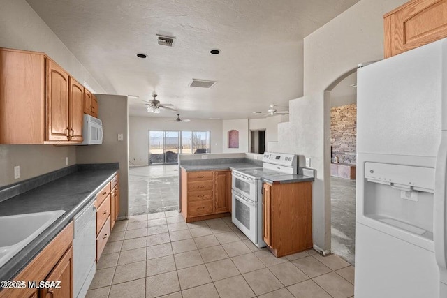 kitchen with sink, white appliances, kitchen peninsula, and light tile patterned floors