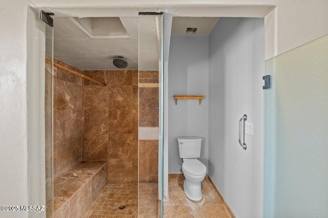 bathroom featuring tiled shower, tile patterned floors, and toilet