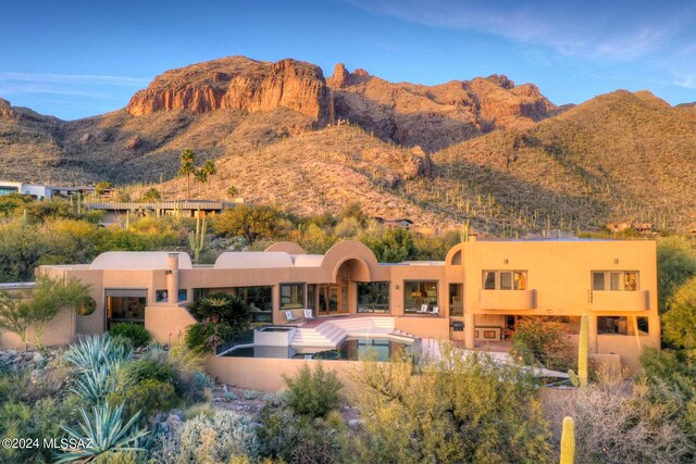 pool at dusk with a mountain view and a patio area