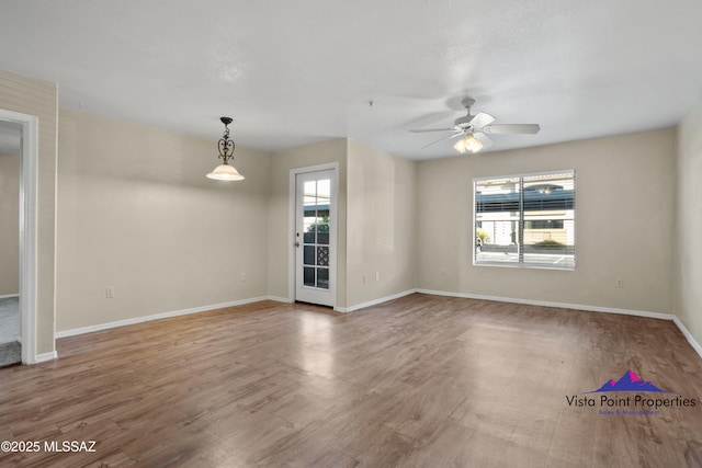 spare room with hardwood / wood-style flooring, ceiling fan, and plenty of natural light