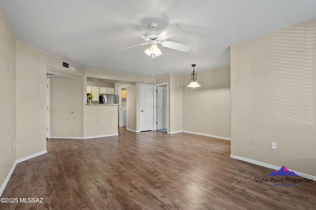 unfurnished living room featuring ceiling fan and dark hardwood / wood-style floors