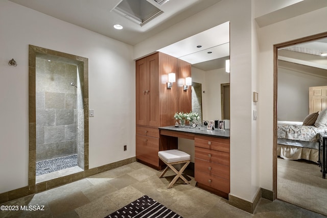 bathroom with vanity and a tile shower