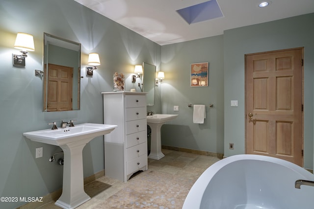 bathroom with double sink and a tub to relax in