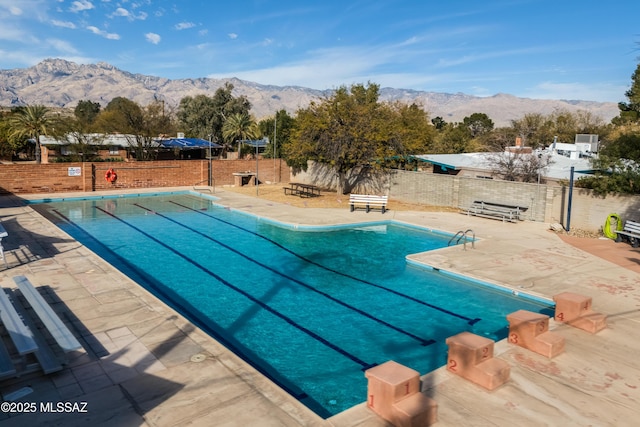 view of pool with a mountain view and a patio area