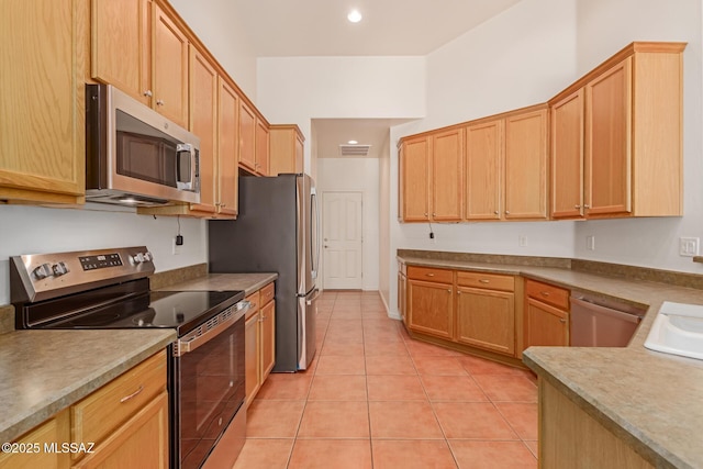 kitchen featuring light tile patterned floors, stainless steel appliances, and sink