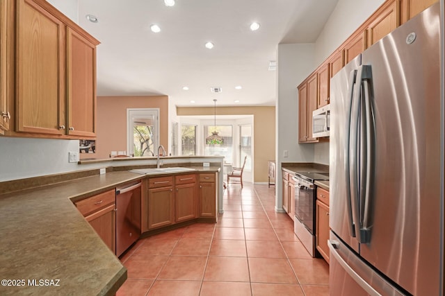 kitchen featuring decorative light fixtures, stainless steel appliances, sink, kitchen peninsula, and light tile patterned floors