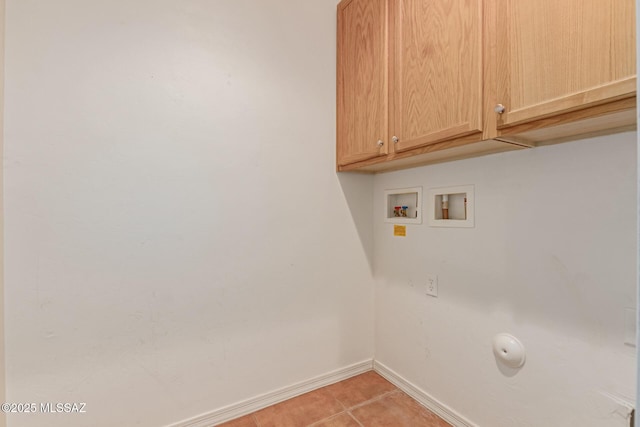 washroom featuring washer hookup, cabinets, and light tile patterned floors