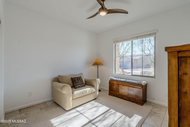 living area with ceiling fan and light tile patterned floors