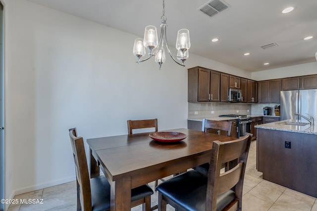 tiled dining room with sink and an inviting chandelier