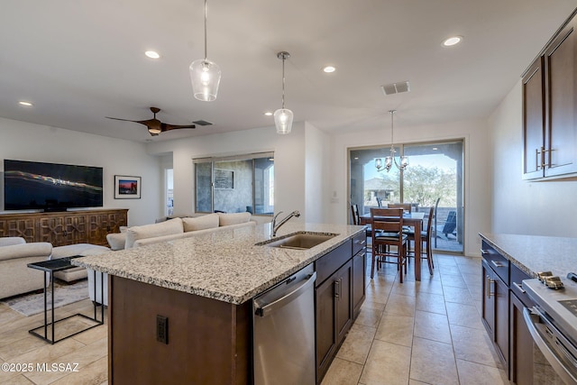 kitchen featuring hanging light fixtures, a kitchen island with sink, sink, dark brown cabinetry, and stainless steel appliances