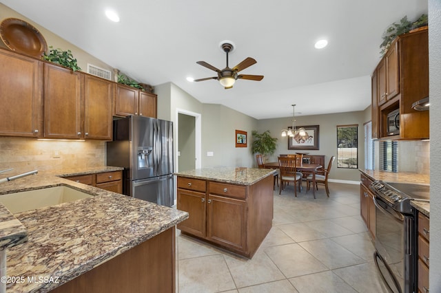 kitchen with lofted ceiling, sink, hanging light fixtures, a center island, and black appliances