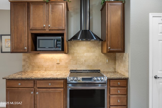 kitchen with stone counters, tasteful backsplash, appliances with stainless steel finishes, and wall chimney exhaust hood