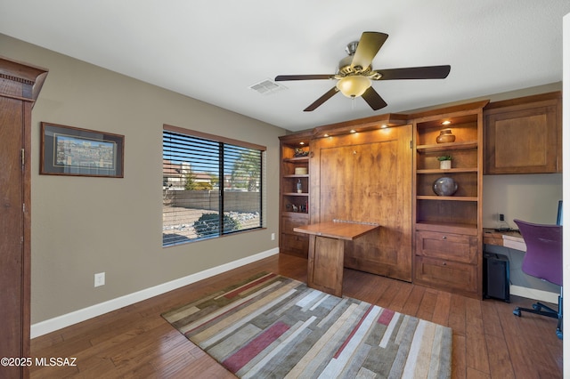 office featuring ceiling fan, dark hardwood / wood-style floors, and built in desk