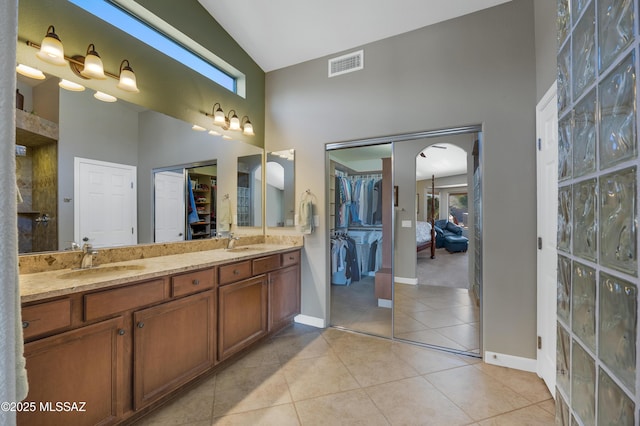 bathroom featuring tile patterned flooring, vanity, vaulted ceiling, and plenty of natural light