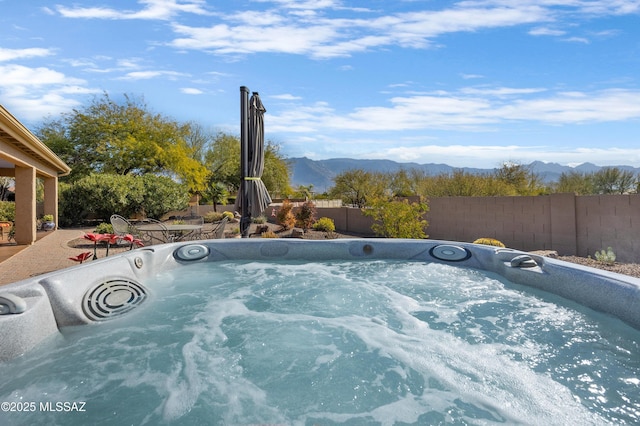 view of swimming pool with a hot tub and a mountain view