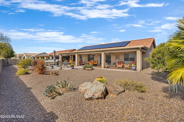 rear view of house featuring a patio, an outdoor hangout area, and solar panels