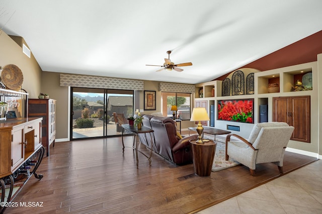 living room with ceiling fan, vaulted ceiling, light hardwood / wood-style flooring, and built in features