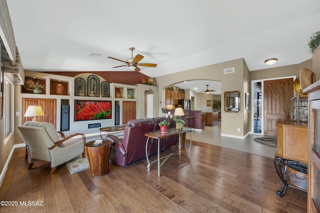 living room with hardwood / wood-style flooring, vaulted ceiling, and ceiling fan