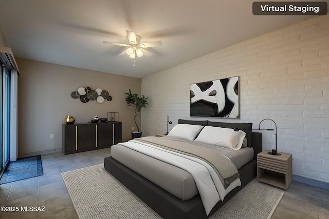 bedroom featuring ceiling fan and brick wall