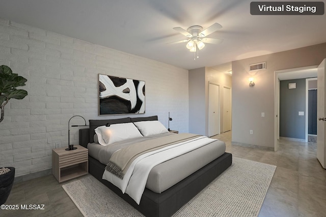 bedroom featuring ceiling fan, brick wall, and a closet