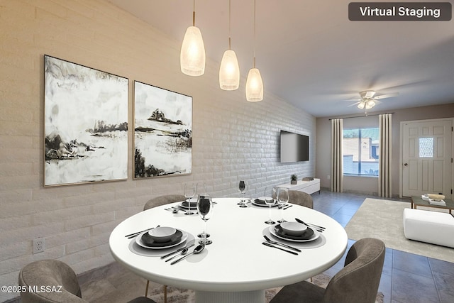 tiled dining room with vaulted ceiling, ceiling fan, and brick wall