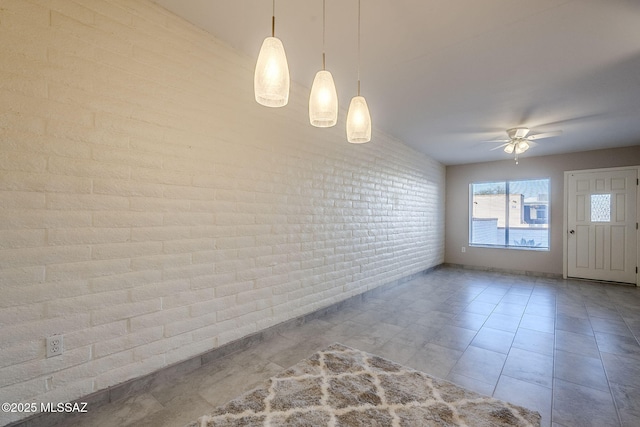 empty room with ceiling fan and brick wall