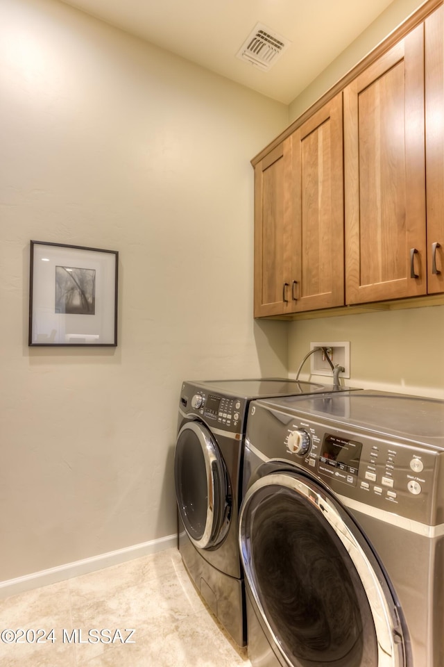 laundry area with cabinets and washing machine and clothes dryer