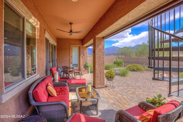 view of patio / terrace featuring ceiling fan, a mountain view, and an outdoor living space