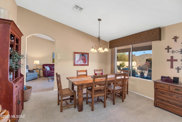 dining area with light carpet and a chandelier