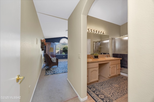 bathroom with lofted ceiling, vanity, and walk in shower