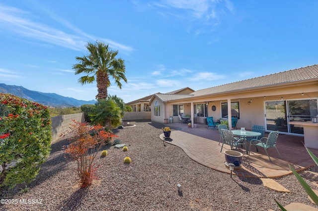 rear view of house featuring a mountain view and a patio area