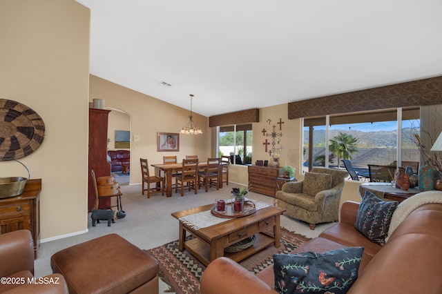 carpeted living room featuring lofted ceiling and an inviting chandelier